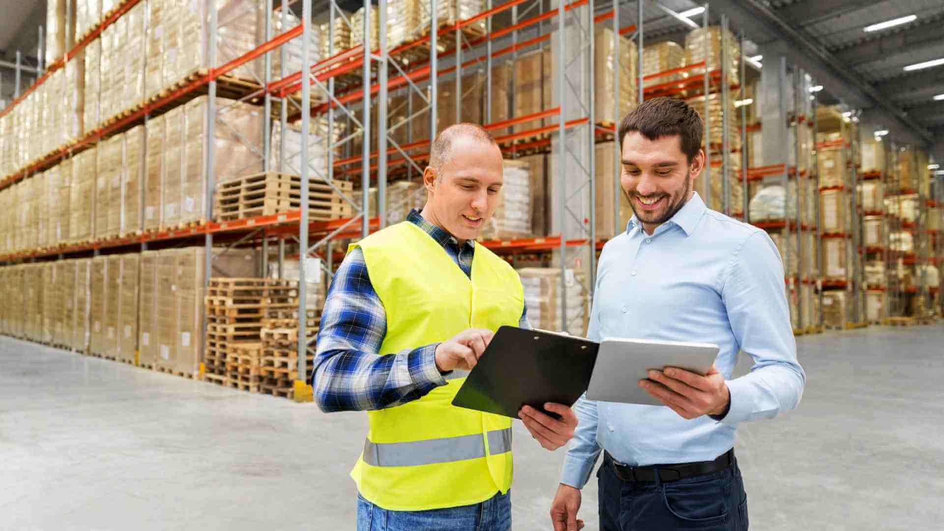 worker and businessman with tablet at warehouse